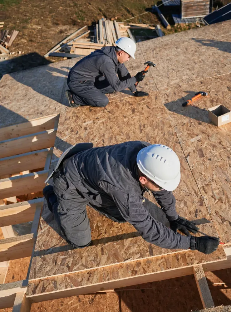 ADU construction in Los Angeles with workers installing roof framing for a modern backyard unit
