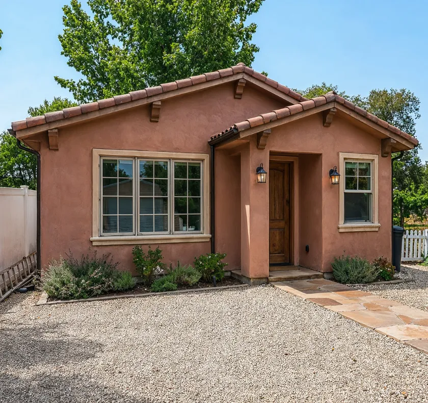Backyard guest house builders in Los Angeles CA showcasing stucco guest house with Spanish style tile roof and clean exterior design